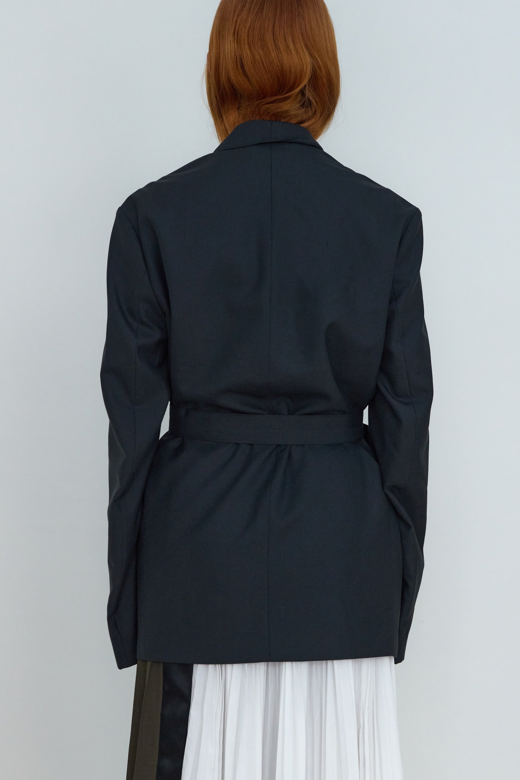 Person wearing a black jacket with a white background