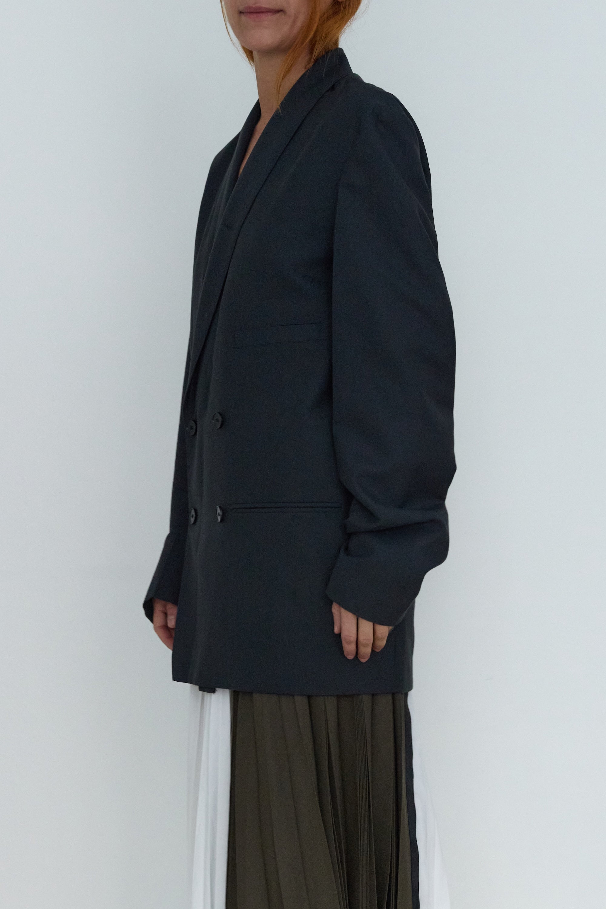 Person wearing a black blazer against a white background