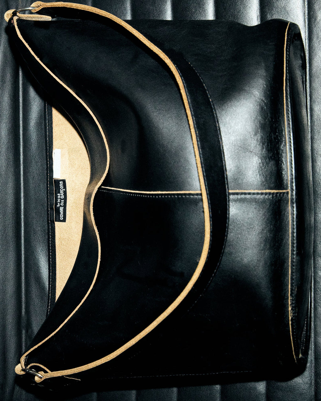 Black handbag with gold accents on a dark background