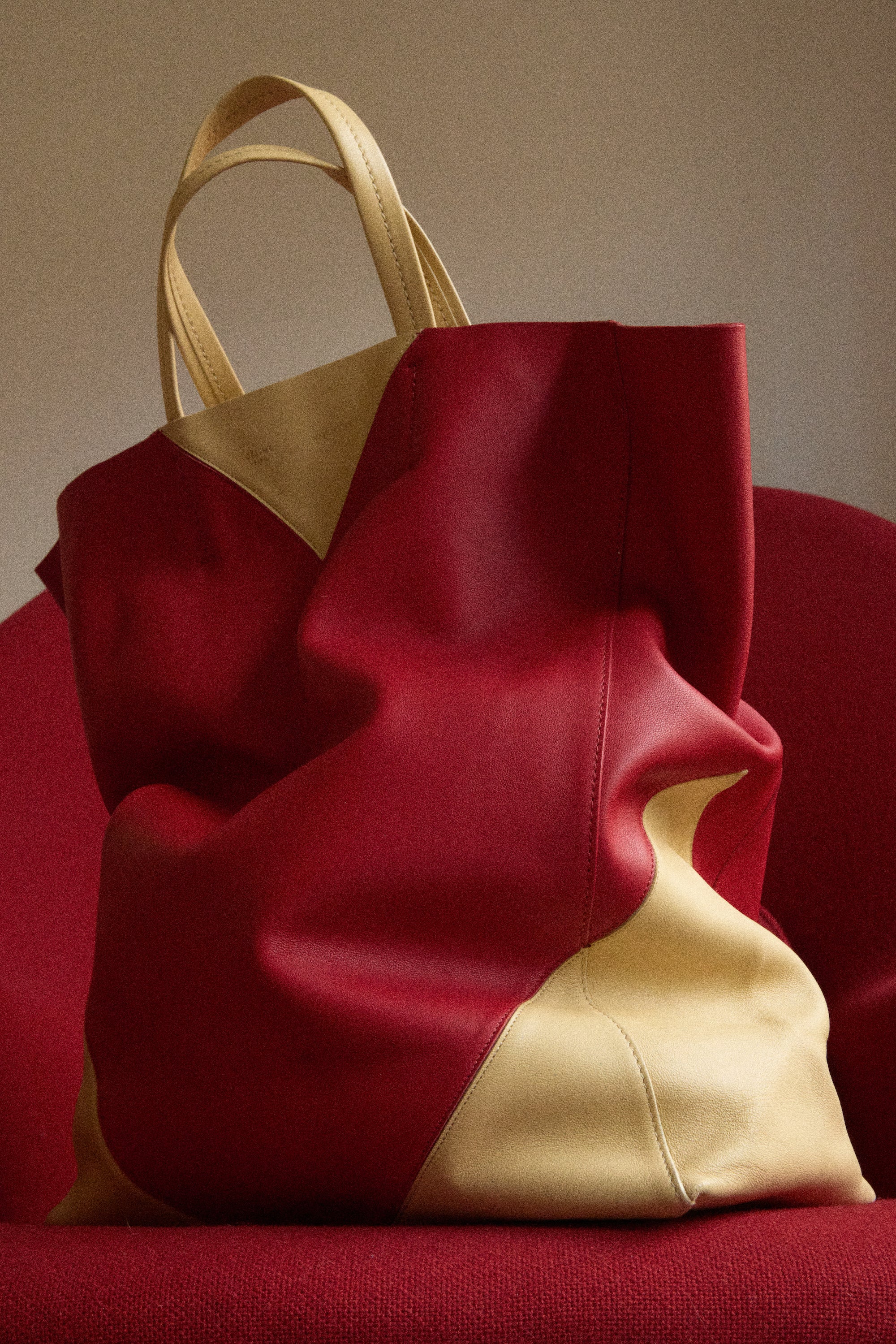 Red and gold handbag on a red surface with a neutral background