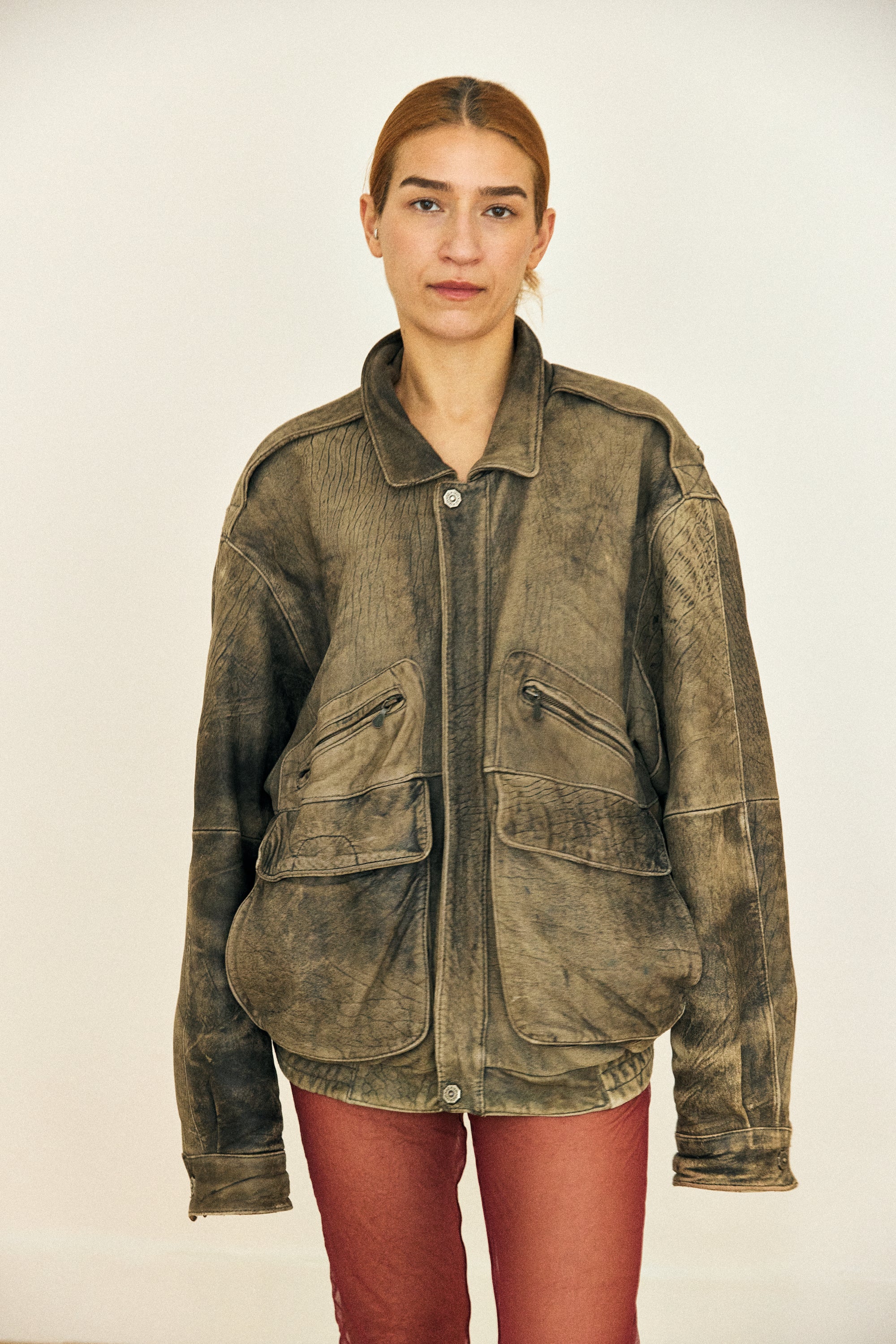 Person wearing a vintage-style jacket on a plain background